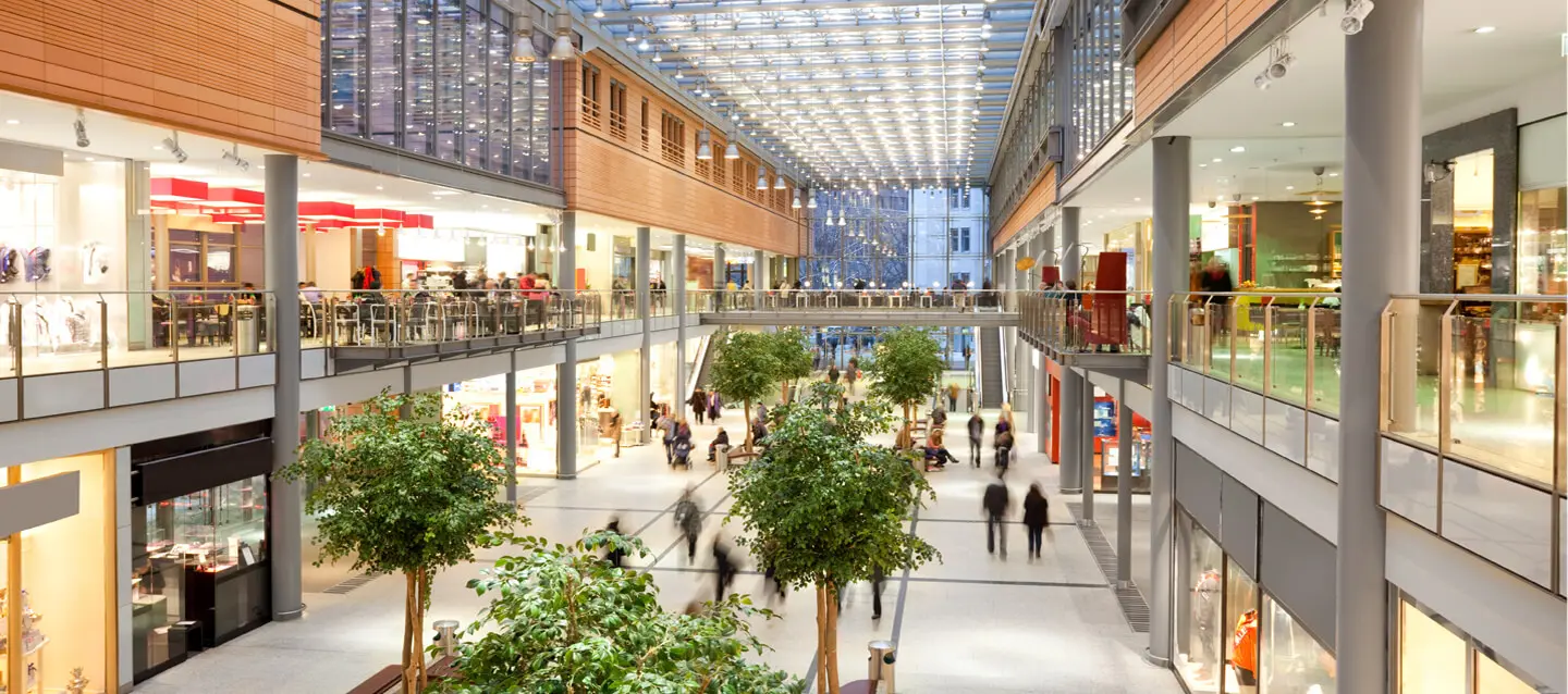 Busy mall interior with shops and people