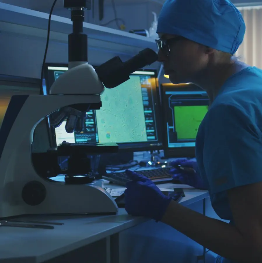 Researcher analyzing samples on microscope