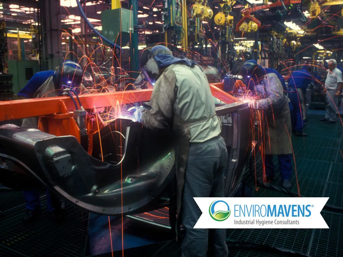 Team welding components in factory setting