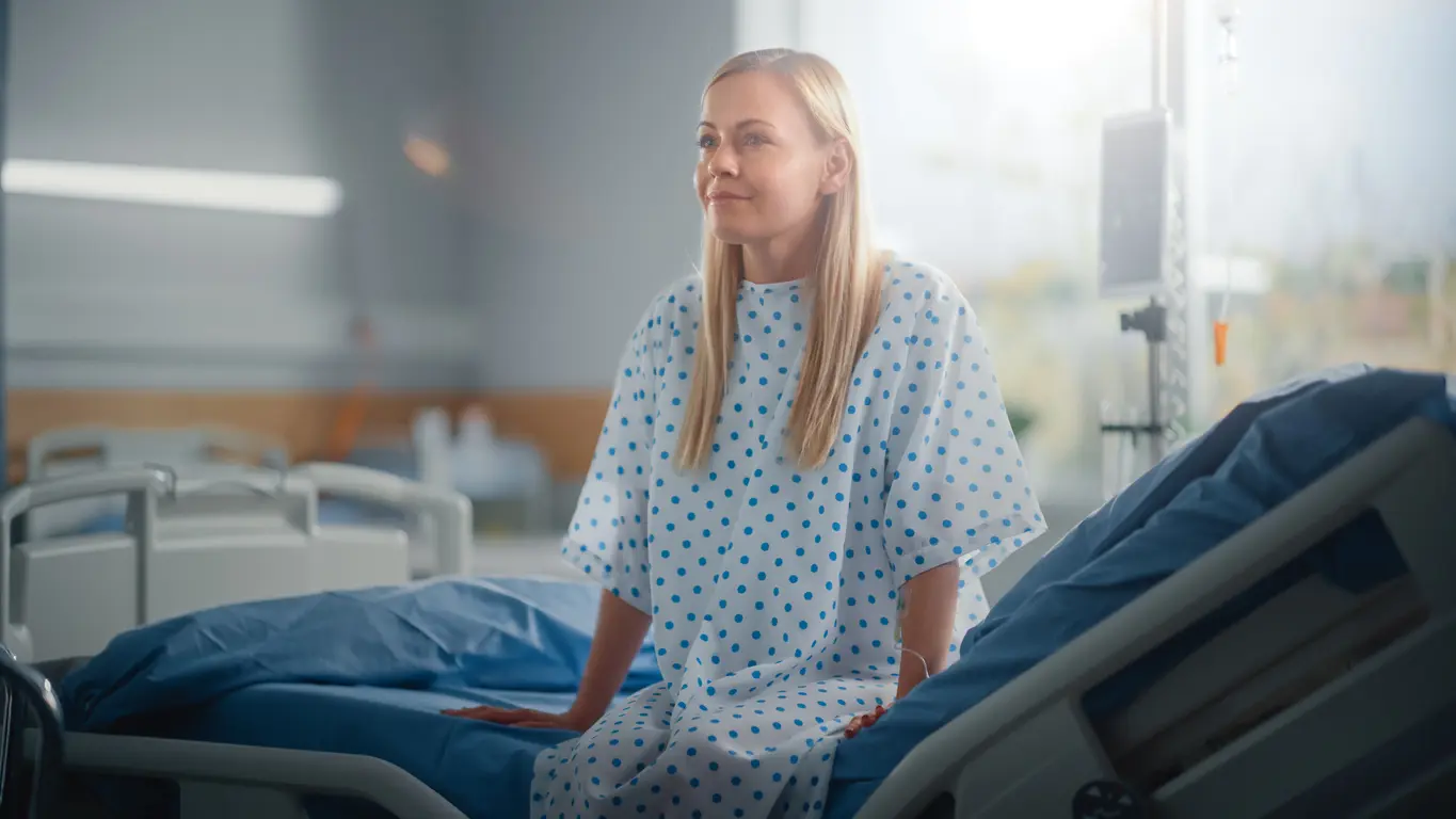 Woman in hospital gown on bed