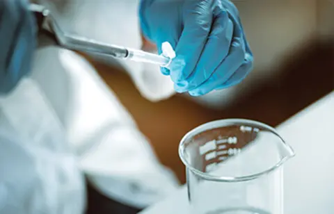 Scientist using pipette in laboratory