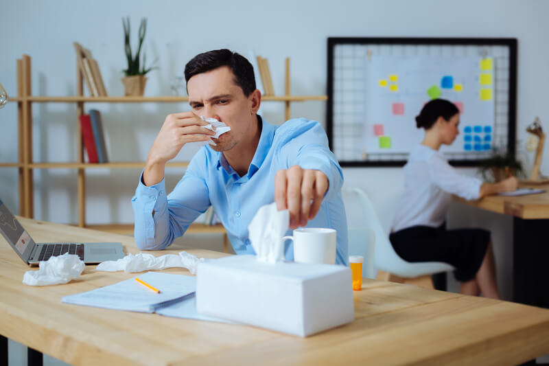 Employee at work experiencing symptoms from a cold