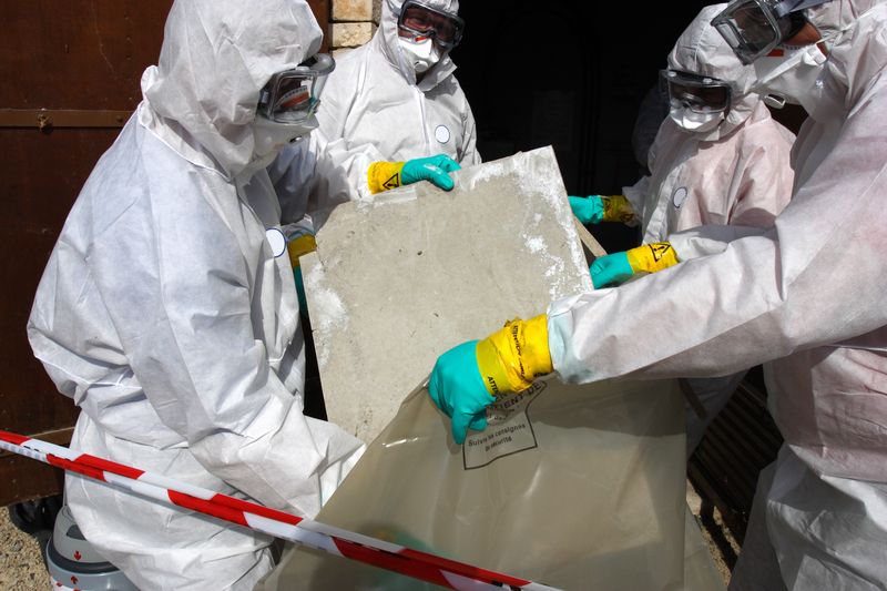 Individuals wearing protective suits throwing out potentially contaminated items