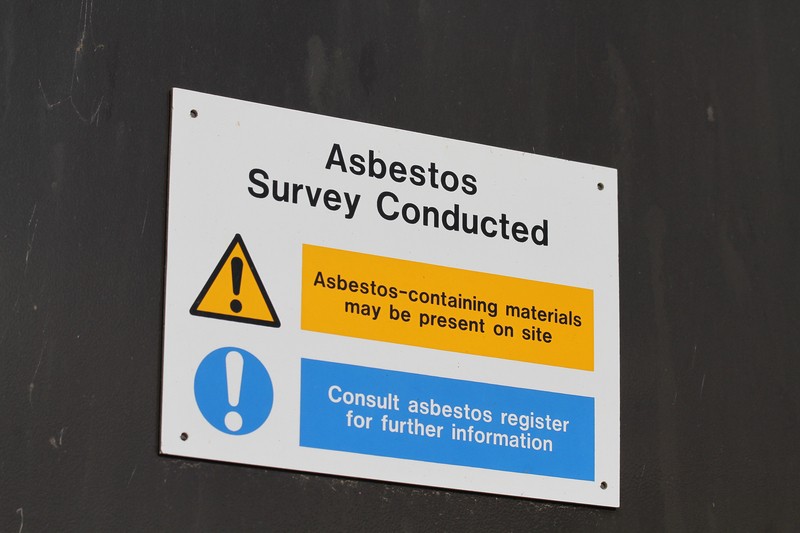 A wall sign indicating completion of an asbestos inspection in Franklin and Knoxville, TN