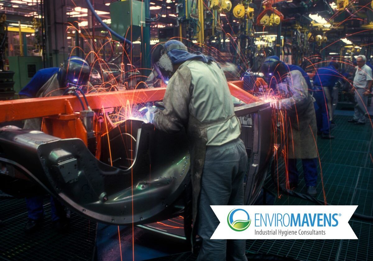 Team welding components in factory setting