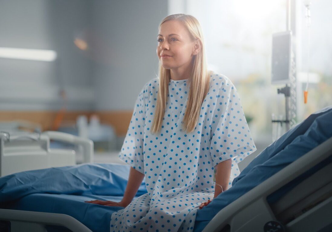 Woman in hospital gown on bed